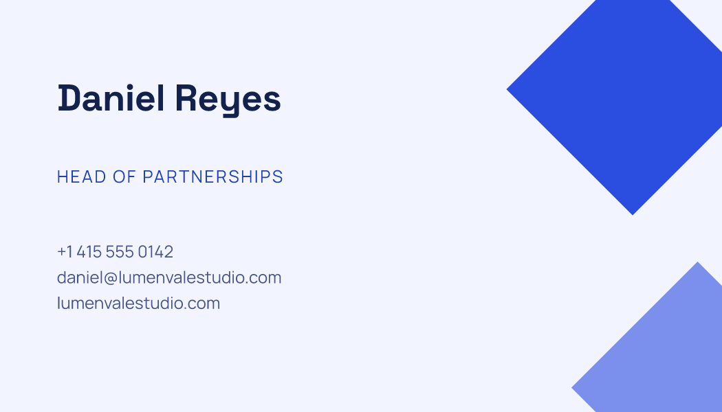 A pale business card with two blue geometric shapes on the right and Daniel Reyes's name, job and contact lines on the left.